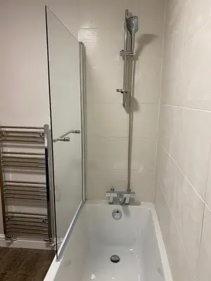 a bathroom with a bath tub with a shower at Clock Tower Apartments No3 in Morecambe