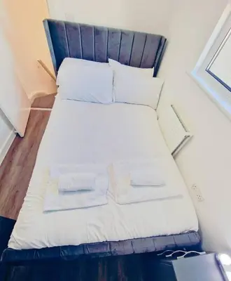 a bed in a room with two towels on it at Beautiful home near LFC Stadium in Liverpool