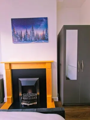 a room with a fireplace with a painting on the wall at Beautiful home near LFC Stadium in Liverpool