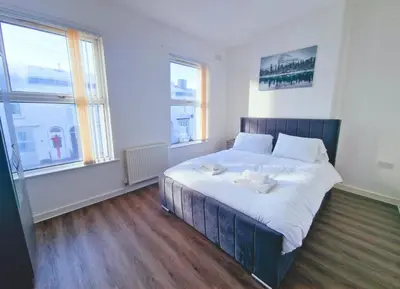 a bedroom with a large bed with two towels on it at Beautiful home near LFC Stadium in Liverpool
