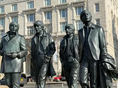 a statue of three men in front of a building at Stylish city centre Penthouse in Liverpool