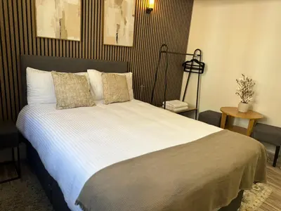 a bedroom with a large bed with white sheets and pillows at Stylish city centre Penthouse in Liverpool