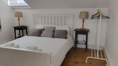 a bedroom with a large white bed with two lamps at Charming six bedroom townhouse citystay close to city centre in Liverpool