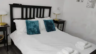 a bedroom with a white bed with two blue pillows at Charming six bedroom townhouse citystay close to city centre in Liverpool