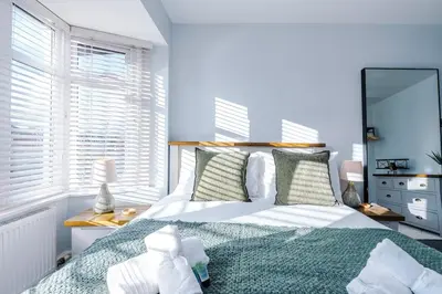a bedroom with a bed and a large window at Home in Preston 4 beds FAST WIFI in Samlesbury