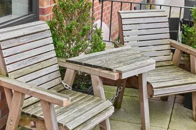 two wooden chairs and a picnic table on a patio at Host & Stay - Chic Townhouse by the Docks in Liverpool