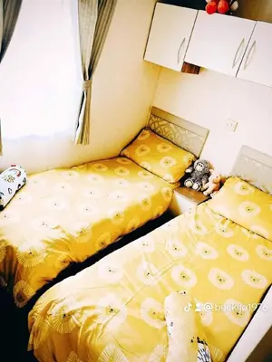 two beds sitting next to each other in a bedroom at Metcalfes family caravan in Heysham