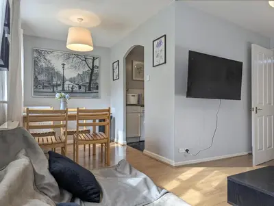 a living room with a couch and a tv on a wall at Vintage 2-Bed City Centre Gem Free Parking in Liverpool
