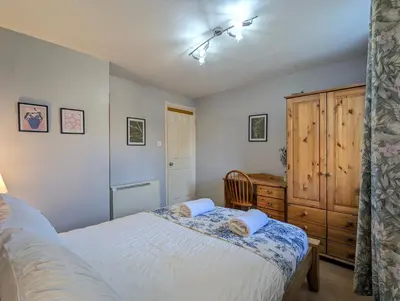 a bedroom with a white bed and a wooden cabinet at Vintage 2-Bed City Centre Gem Free Parking in Liverpool