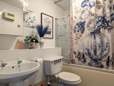 a bathroom with a toilet and a sink and a vase at Vintage 2-Bed City Centre Gem Free Parking in Liverpool