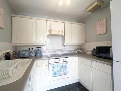 a kitchen with white cabinets and a stove top oven at Vintage 2-Bed City Centre Gem Free Parking in Liverpool