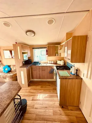 a kitchen with wooden cabinets and a counter top at Ocean Pearl Home in Heysham