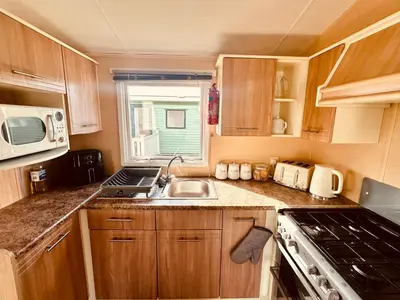 a small kitchen with a sink and a stove at Ocean Pearl Home in Heysham