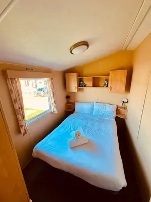 a small bedroom with a bed with a towel on it at Ocean Pearl Home in Heysham