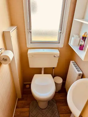 a small bathroom with a toilet and a window at Ocean Pearl Home in Heysham