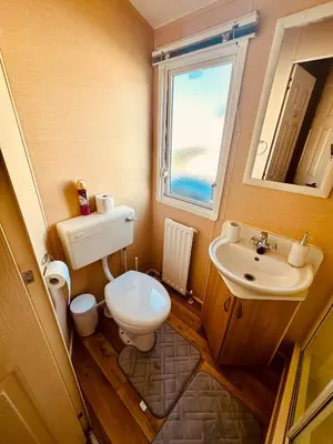 a small bathroom with a toilet and a sink at Ocean Pearl Home in Heysham