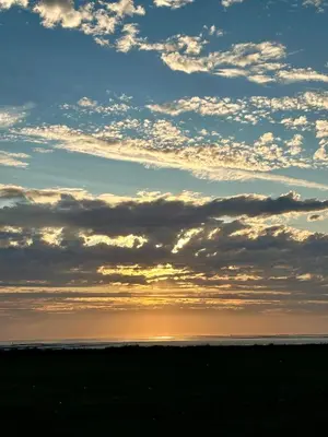 a sunset on the beach with a cloudy sky at Ocean Pearl Home in Heysham