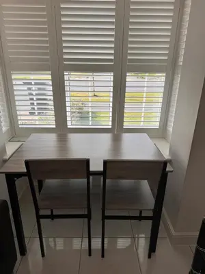 a wooden table and two chairs in front of a window at Spacious Luxurious Serviced Accommodation 7 in Preston
