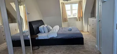 a bedroom with a bed with a mirror and a window at Spacious Luxurious Serviced Accommodation 7 in Preston