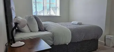 a bedroom with a bed with white sheets and a lamp at Spacious Luxurious Serviced Accommodation 7 in Preston