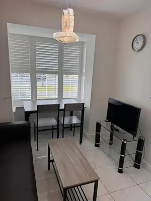 a living room with a table and chairs and a tv at Spacious Luxurious Serviced Accommodation 7 in Preston