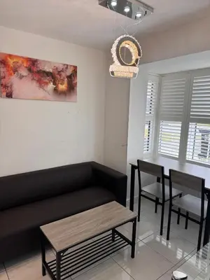 a living room with a black couch and a table at Spacious Luxurious Serviced Accommodation 7 in Preston