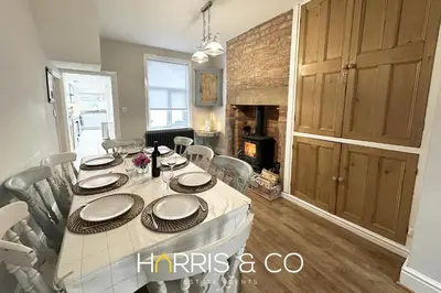 a dining room with a table and a fireplace at Admirals Rest in Fleetwood