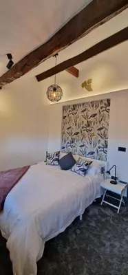 a bedroom with a large white bed and a table at Weavers Cottage Whalley in Whalley