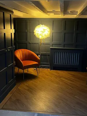 a living room with a chair and a lamp at Weavers Cottage Whalley in Whalley