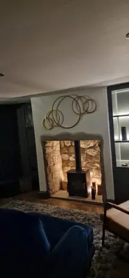 a living room with a stone fireplace with a tv at Weavers Cottage Whalley in Whalley