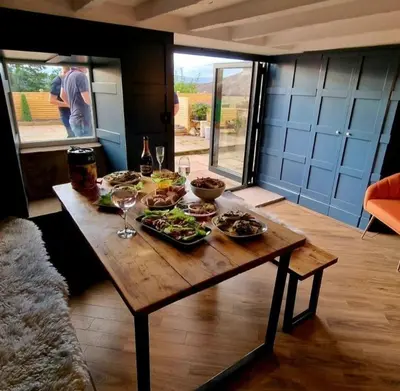 a wooden table with food and wine glasses on it at Weavers Cottage Whalley in Whalley