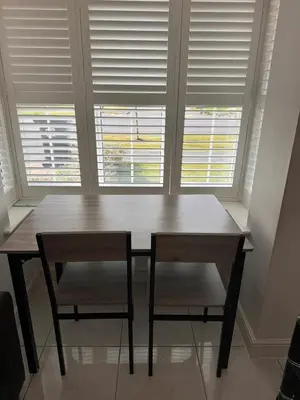a wooden table and two chairs in front of a window at House - Sleeps 11 - Parking - Station Close in Preston