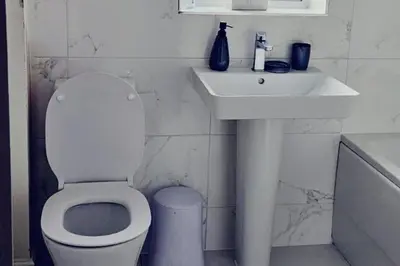 a white bathroom with a toilet and a sink at House - Sleeps 11 - Parking - Station Close in Preston