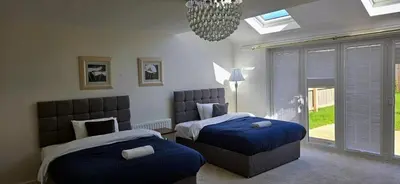a bedroom with two beds and a window at House - Sleeps 11 - Parking - Station Close in Preston