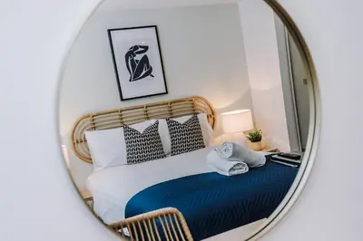 a bedroom with a bed in a mirror at Flatzy - City Centre Flat With Free Parking in Liverpool