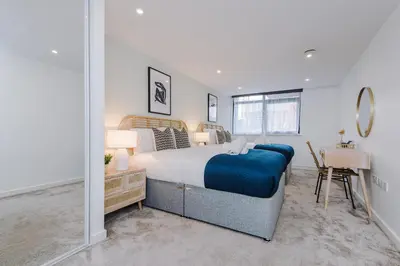 a bedroom with a large bed and a desk at Flatzy - City Centre Flat With Free Parking in Liverpool