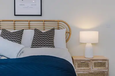 a bedroom with a bed and a lamp on a night stand at Flatzy - City Centre Flat With Free Parking in Liverpool