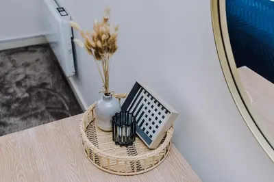 a basket table with a vase and a laptop on it at Flatzy - City Centre Flat With Free Parking in Liverpool