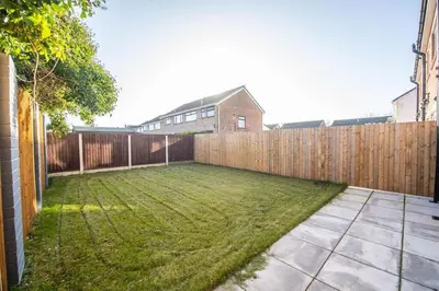 a backyard with a wooden fence and grass at Stylish 3-Bed Home-Liverpool in Liverpool