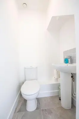 a white bathroom with a toilet and a sink at Stylish 3-Bed Home-Liverpool in Liverpool