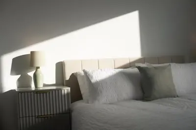 a white bed with two lamps on a night stand at Stylish 3-Bed Home-Liverpool in Liverpool