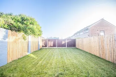a backyard with a wooden fence and grass at Stylish 3-Bed Home-Liverpool in Liverpool