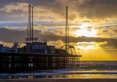 a pier on the beach with the sunset in the background at The Sands Hotel in Blackpool