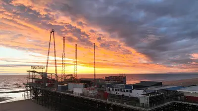 a pier on the beach with a sunset at The Sands Hotel in Blackpool