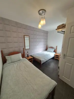 a bedroom with two beds in a room at Ulverston Town Centre Ground Floor Apartment in Ulverston