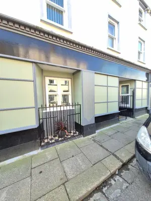 a building with two garages on the side of it at Ulverston Town Centre Ground Floor Apartment in Ulverston