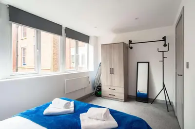 a bedroom with a blue bed and two white towels at Convenient 1 Bedroom Apartment in Preston Centre in Preston