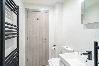 a bathroom with a white toilet and a wooden door at Convenient 1 Bedroom Apartment in Preston Centre in Preston