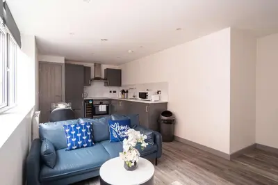 a living room with a blue couch and a table at Convenient 1 Bedroom Apartment in Preston Centre in Preston