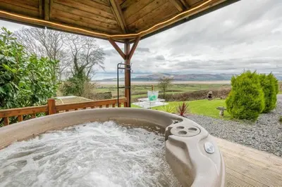 a bath tub with water in it on a deck at Haven Lodge Kirkby In Furness, with views to the estuary and hot tub, ideal romantic break in Soutergate
